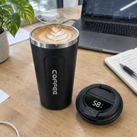 Smart coffee cup with a flat white on an office desk, lid off beside it